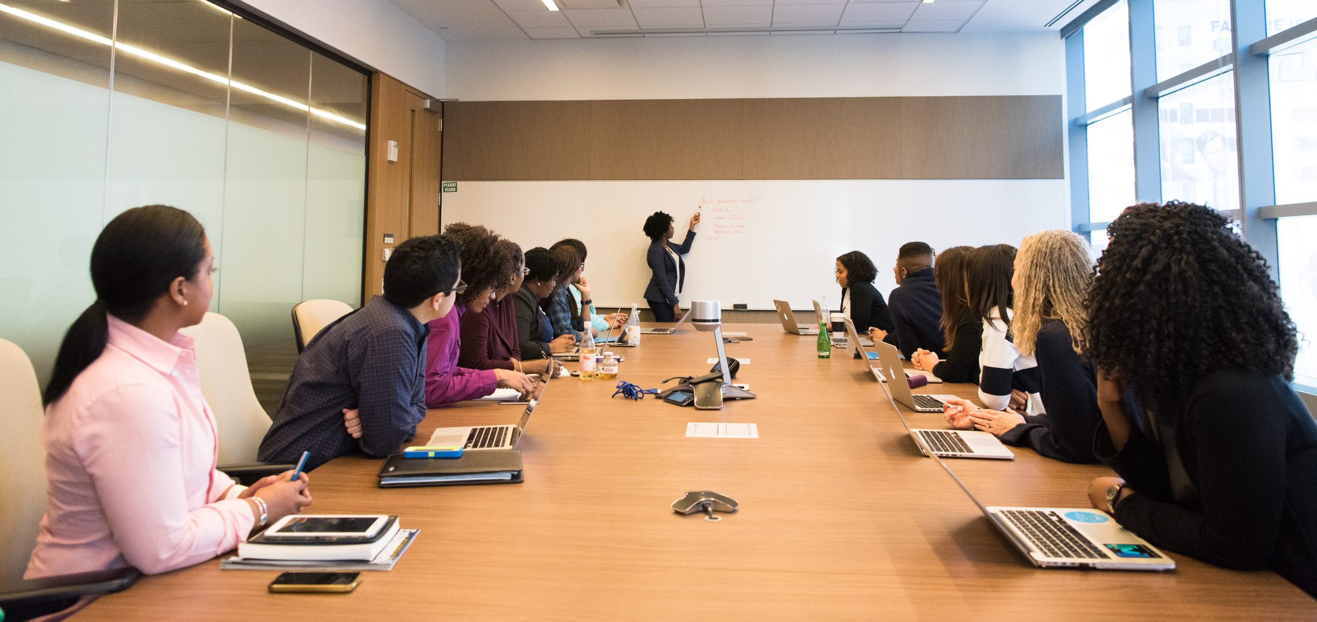 business professionals having meeting inside conference room looking at whiteboard